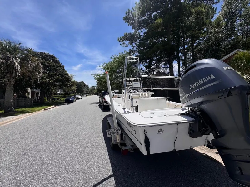 Slide: The Image of 2018 Intruder 23 SKIFF boat with Yamaha engine parked on a sunny residential street. - 4