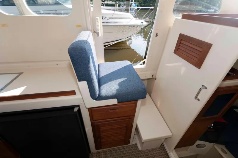 Slide: The Image of 2006 Rosborough RF-246 Sedan Cruiser interior with blue cushioned seat and wooden cabinetry. - 16