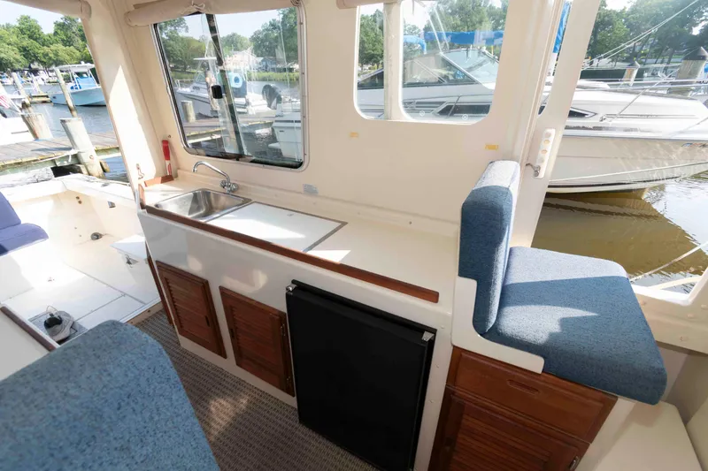 Slide: The Image of 2006 Rosborough RF-246 Sedan Cruiser interior with kitchenette and seating, docked at marina. - 17