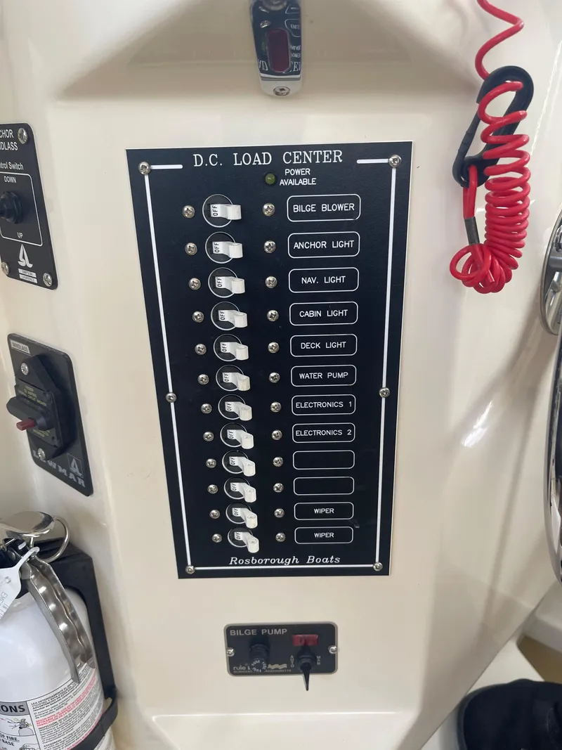 Slide: The Image of D.C. load center panel on 2006 Rosborough RF-246 Sedan Cruiser with labeled switches and fire extinguisher. - 19