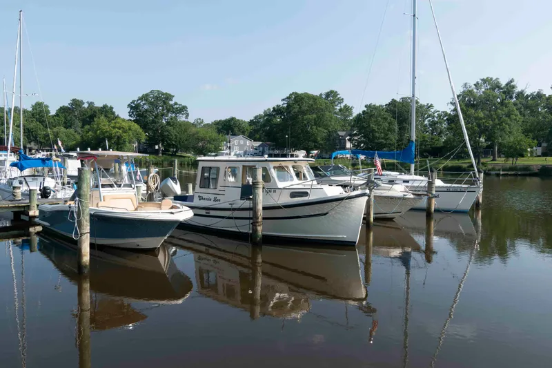 Slide: The Image of Boats docked at a marina, featuring a 2006 Rosborough RF-246 Sedan Cruiser. - 2