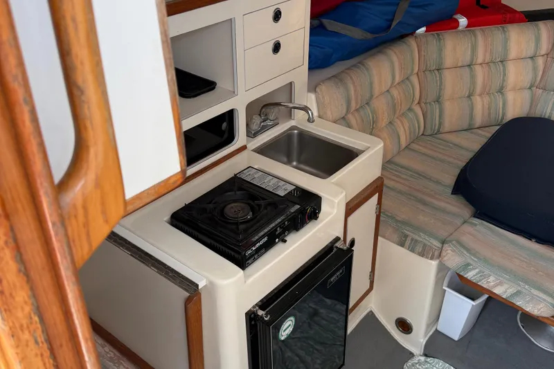 Slide: The Image of Interior of 1994 Albin 28 Tournament Express with kitchenette and seating area. - 11