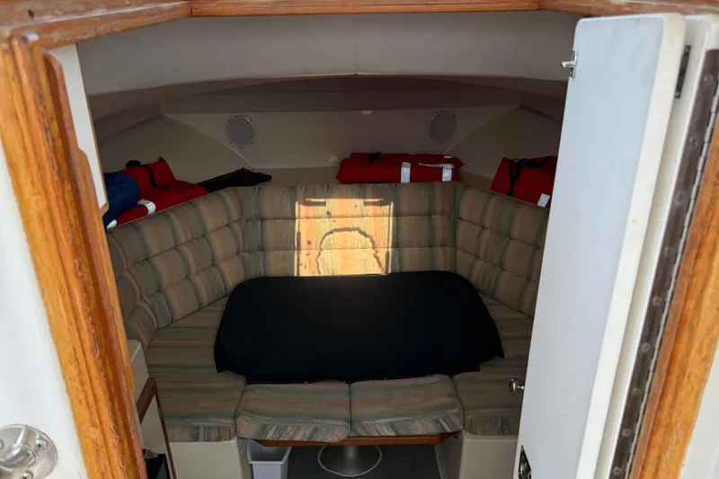 Slide: The Image of Interior cabin of 1994 Albin 28 Tournament Express with cushioned seating and life jackets. - 12