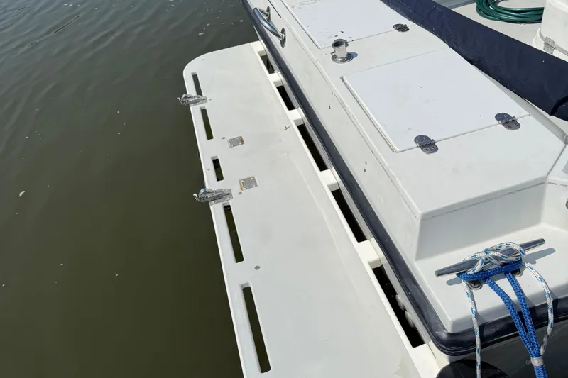 Slide: The Image of 1994 Albin 28 Tournament Express boat deck with cleats and rope, docked on calm water. - 17