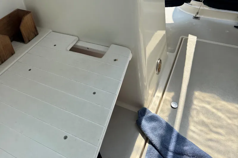 Slide: The Image of Interior of 1994 Albin 28 Tournament Express boat with white deck and blue towel. - 19