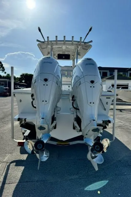 Slide: The Image of 2026 Pair Customs 24 Center Console DV with dual outboard engines, rear view. - 10