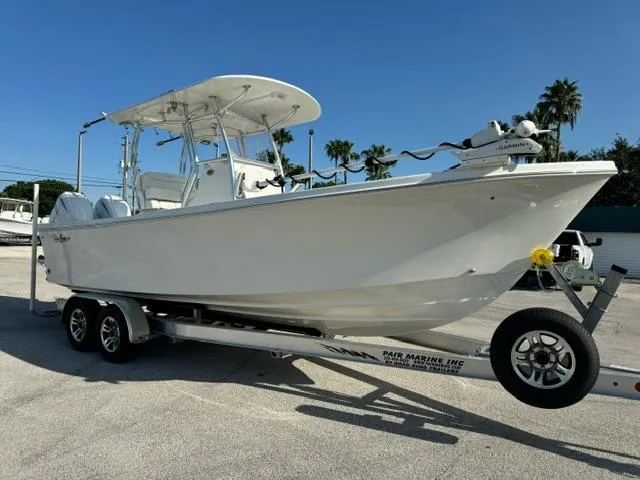 Slide: The Image of 2026 Pair Customs 24 Center Console DV boat on trailer, sunny day, palm trees in background. - 5