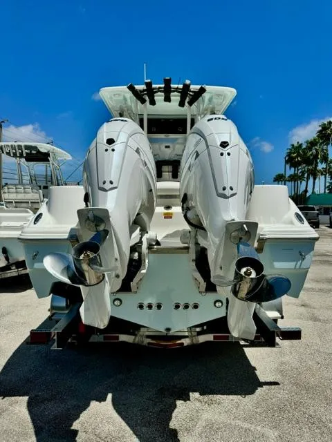 Slide: The Image of 2026 Key West 260 CC boat with dual outboard engines, parked under a clear blue sky. - 2