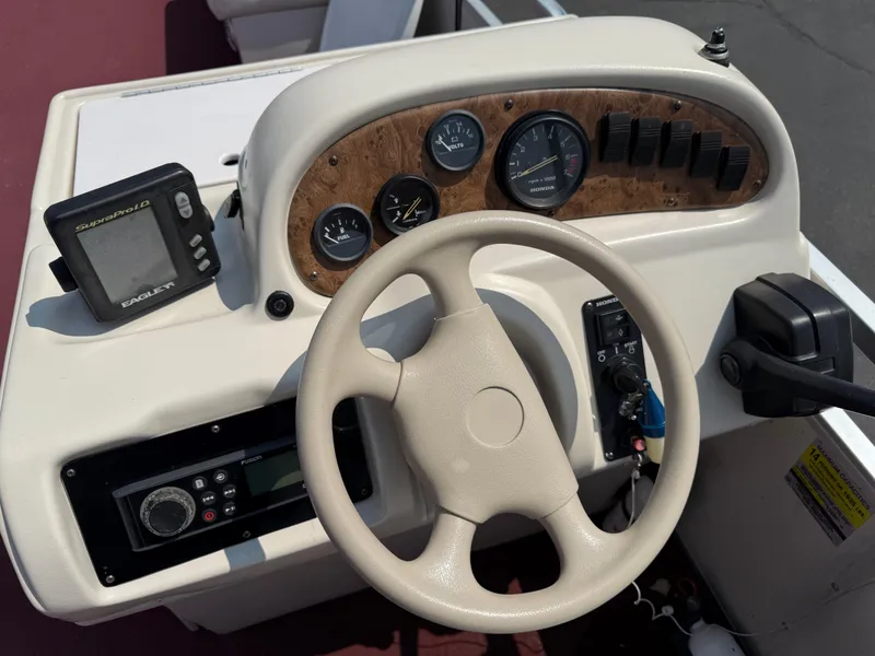 Slide: The Image of Steering console of a 1998 Sweetwater 24RE boat with gauges and controls. - 11