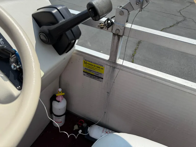Slide: The Image of 1998 Sweetwater 24RE boat interior with steering wheel, throttle, and safety equipment. - 12