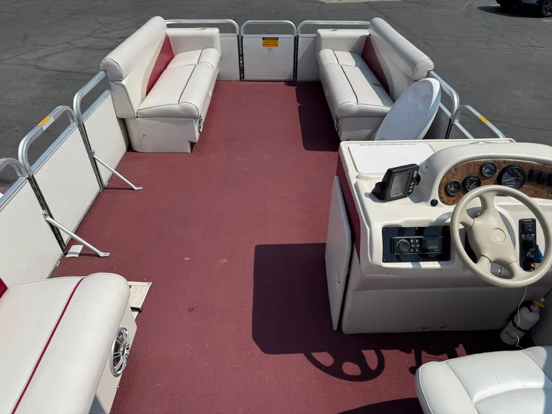 Slide: The Image of Interior of a 1998 Sweetwater 24RE pontoon boat with red carpet and white seating. - 13
