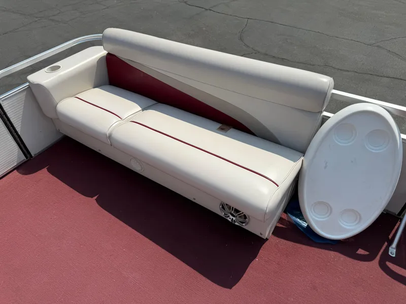 Slide: The Image of Sweetwater 24RE 1998 boat seating with red accents and cup holder on red carpet. - 4