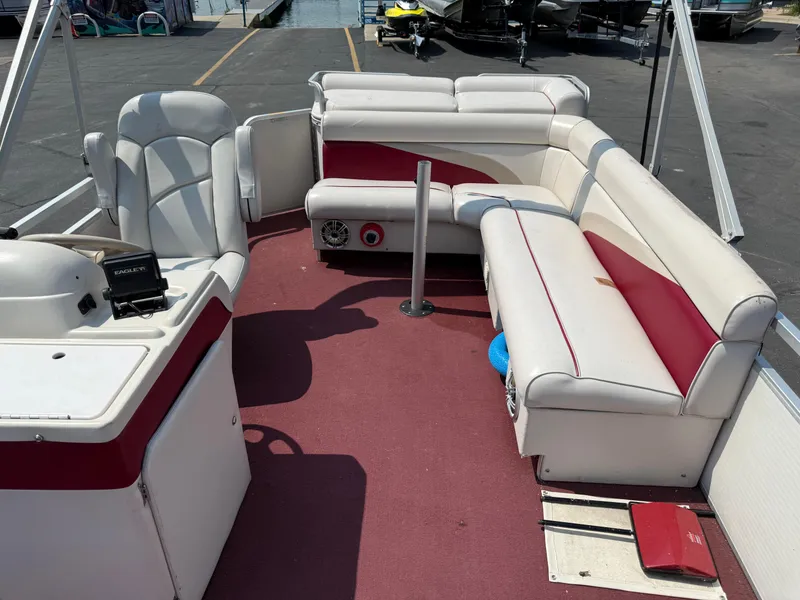 Slide: The Image of 1998 Sweetwater 24RE pontoon boat interior with red and white seating and steering console. - 6