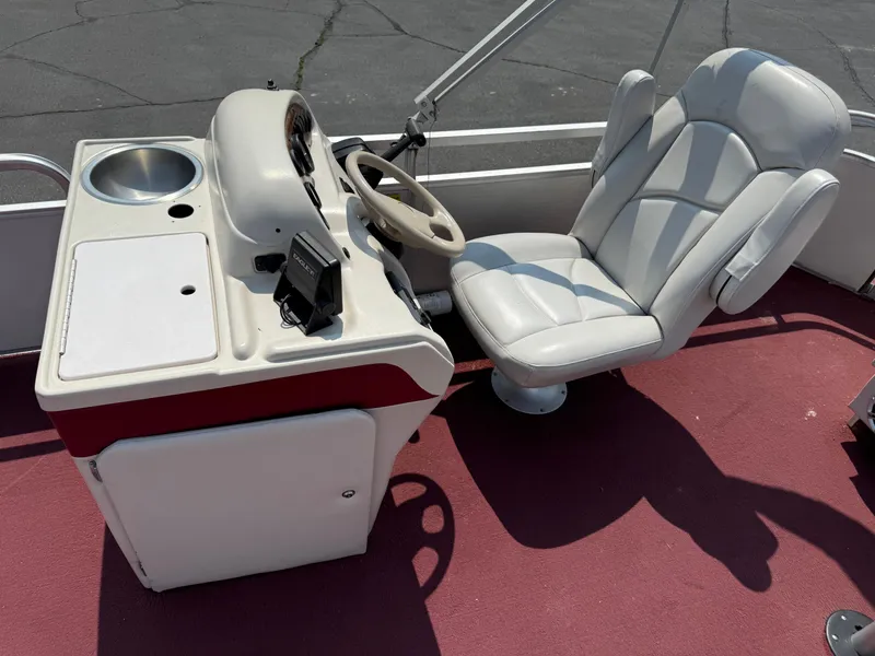 Slide: The Image of Captain's chair and console on a 1998 Sweetwater 24RE boat, featuring a steering wheel and controls. - 7