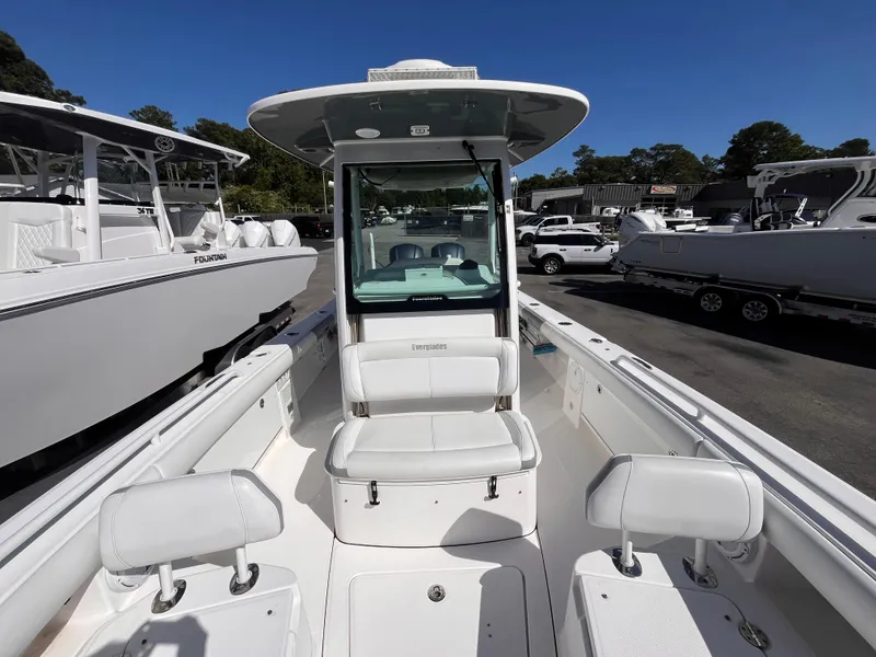 Slide: The Image of 2017 Everglades 273 Center Console boat with white seating and console, parked outdoors. - 11
