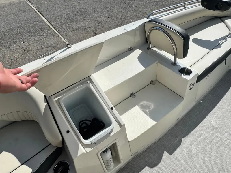 Slide: The Image of 2021 Stingray 212 SC boat interior with open storage compartment and seating area. - 10