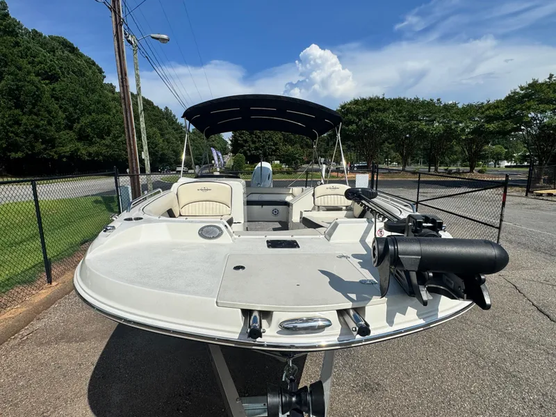Slide: The Image of 2021 Stingray 212 SC boat with canopy, parked on a sunny day. - 5