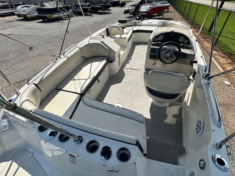 Slide: The Image of 2021 Stingray 212 SC boat interior with spacious seating and modern dashboard. - 6