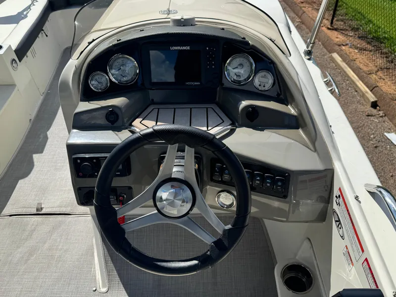 Slide: The Image of 2021 Stingray 212 SC boat dashboard with steering wheel and control panel. - 7