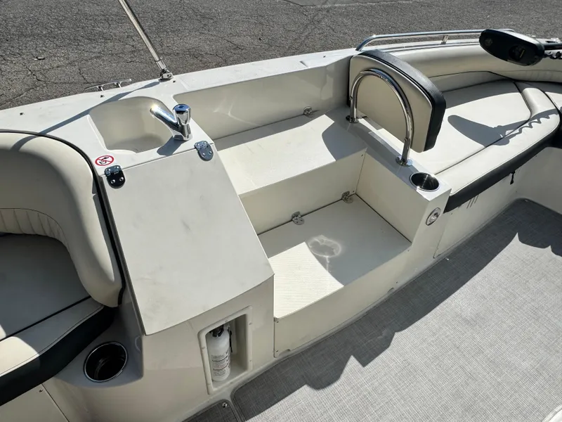Slide: The Image of 2021 Stingray 212 SC boat interior with seating, sink, and cup holders. - 9