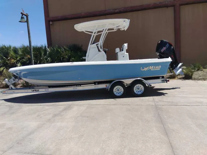 Slide: The Image of 2025 Mako 24 APEX boat on trailer, blue hull, outdoor setting. - 2