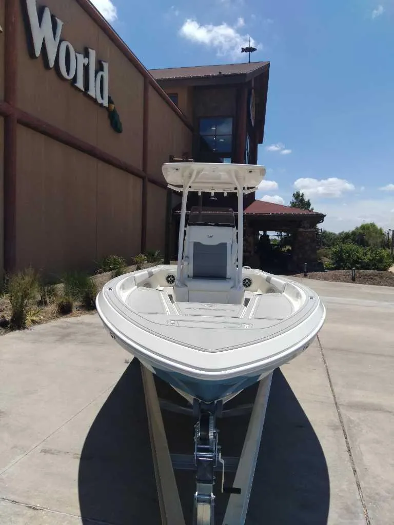 Slide: The Image of 2025 Mako 24 APEX boat displayed outside a store under a clear blue sky. - 3