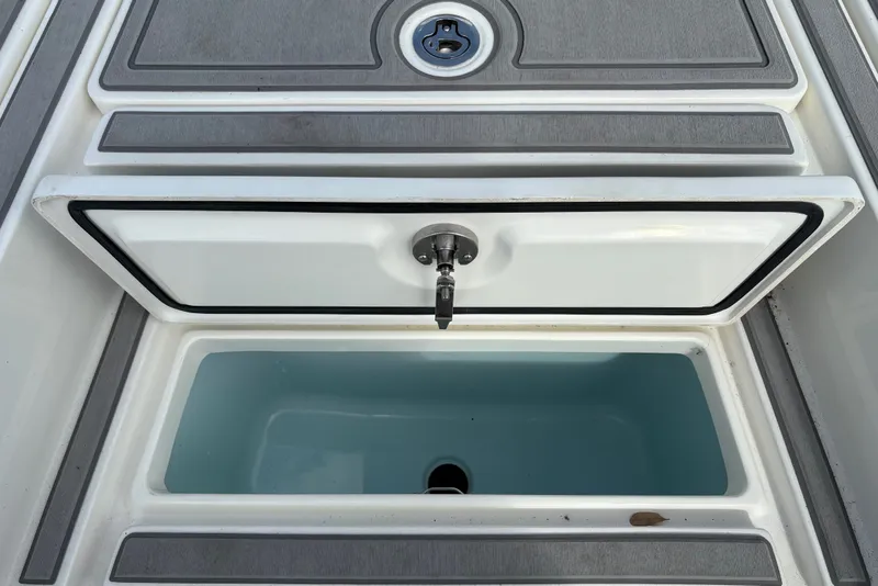 Slide: The Image of Open storage compartment on 2025 Mako 24 APEX boat, featuring sleek design and durable materials. - 9