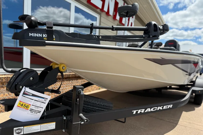 Slide: The Image of 2025 Tracker Savage 215 boat on trailer, displayed outdoors with price tag. - 5