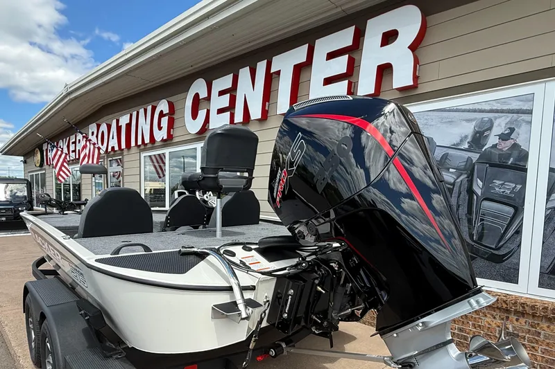 Slide: The Image of 2025 Tracker Savage 215 boat displayed at a boating center with American flags. - 6