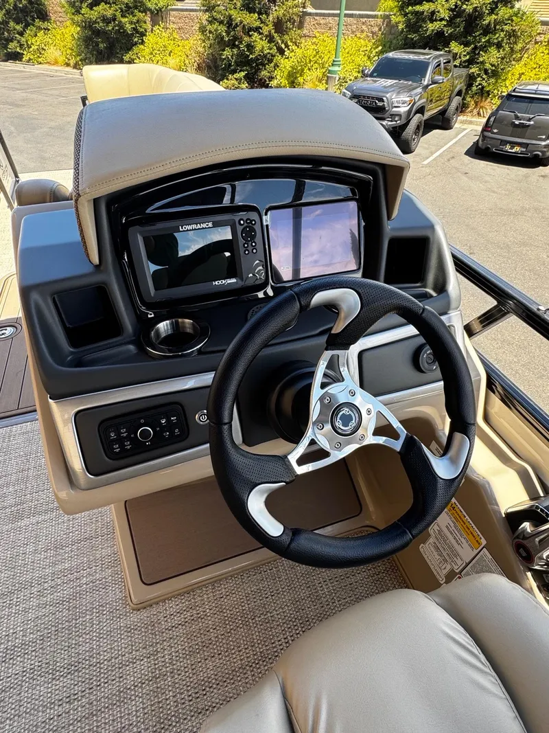 Slide: The Image of 2025 Regency 250 DL3 boat dashboard with steering wheel and navigation system. - 3