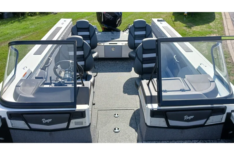 Slide: The Image of 2025 Ranger VX1988 WT boat interior with seating and steering wheel, parked on grass. - 4