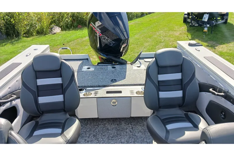 Slide: The Image of Interior of 2025 Ranger VX1988 WT boat with dual seats and motor, on grassy background. - 100