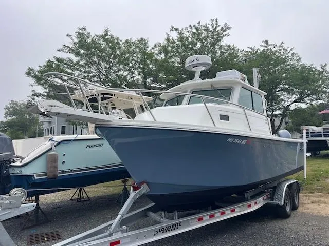 Slide: The Image of 2022 Parker 2520 XLD Sport Cabin boat on trailer, parked outdoors. - 8