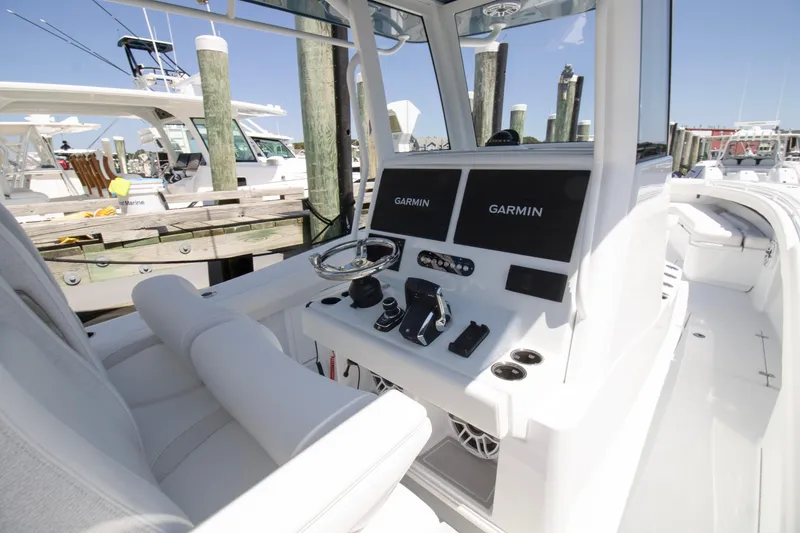 Slide: The Image of 2026 Yellowfin 36 Offshore boat cockpit with Garmin navigation displays at marina. - 11