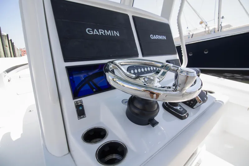 Slide: The Image of 2026 Yellowfin 36 Offshore boat helm with Garmin displays and chrome steering wheel. - 12
