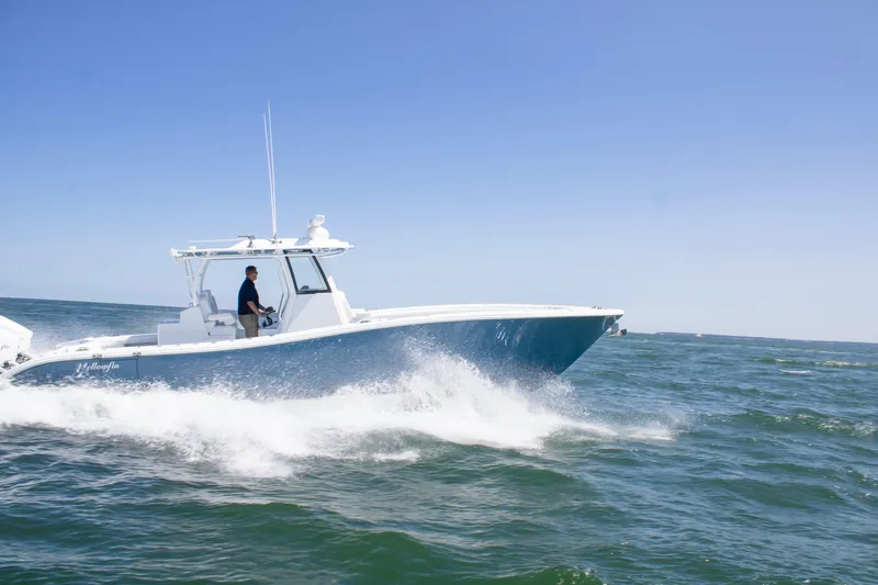 Slide: The Image of 2026 Yellowfin 36 Offshore boat cruising on open water under clear blue sky. - 2