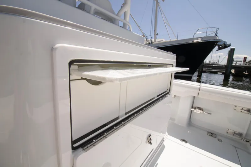 Slide: The Image of 2026 Yellowfin 36 Offshore boat interior with open storage compartment at marina. - 22