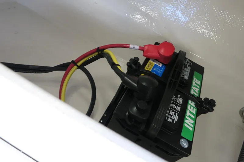 Slide: The Image of Battery compartment of 2025 Chaparral 21 SSi Outboard boat with connected cables. - 13