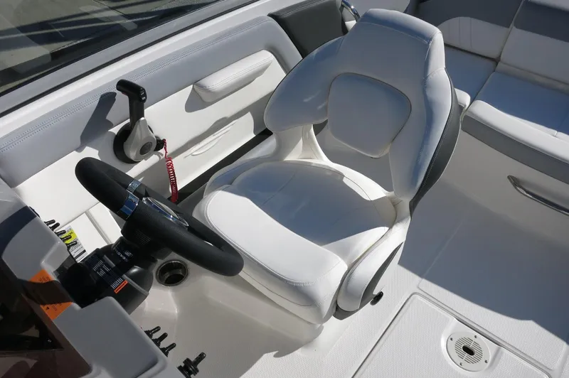 Slide: The Image of 2025 Chaparral 21 SSi Outboard boat interior with white captain's seat and steering wheel. - 21