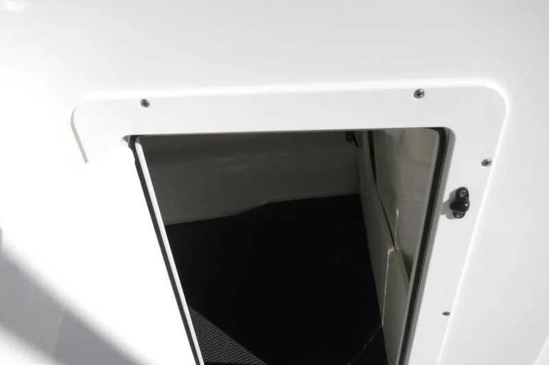 Slide: The Image of 2025 Chaparral 21 SSi Outboard storage compartment with open hatch, showcasing interior space. - 33