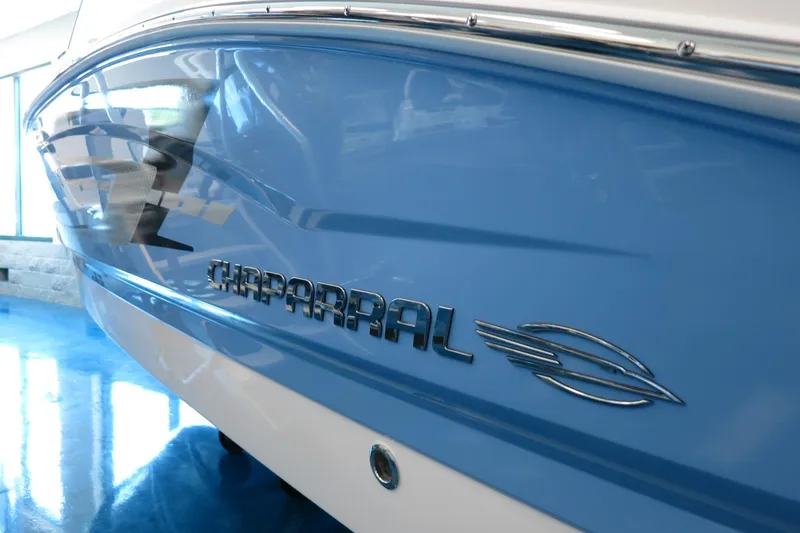 Slide: The Image of 2025 Chaparral 21 SSi Outboard boat, blue hull with logo, in showroom. - 40
