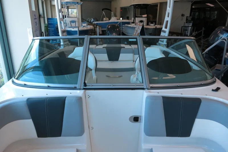 Slide: The Image of 2025 Chaparral 21 SSi Outboard boat interior with seating and windshield in showroom. - 49