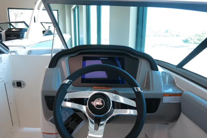 Slide: The Image of 2025 Chaparral 21 SSi Outboard dashboard with steering wheel and digital display. - 53