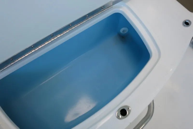Slide: The Image of 2025 Chaparral 21 SSi Outboard boat storage compartment, blue interior, white exterior. - 58
