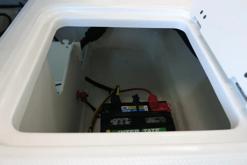 Slide: The Image of Battery compartment of 2025 Chaparral 21 SSi Outboard boat, featuring Interstate battery. - 61