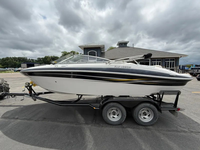 Slide: The Image of 2005 Four Winns Horizon 200 boat on trailer, parked outdoors under cloudy sky. - 2