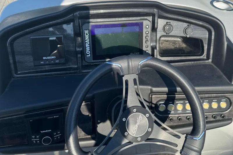 Slide: The Image of 2023 Bentley Pontoons 250 Elite Admiral dashboard with steering wheel and electronic displays. - 2