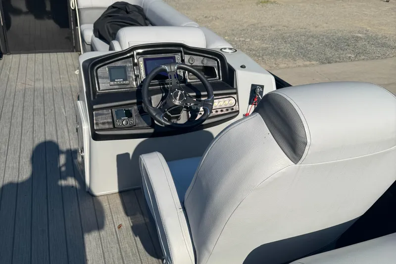 Slide: The Image of 2023 Bentley Pontoons 250 Elite Admiral dashboard with steering wheel and controls. - 8