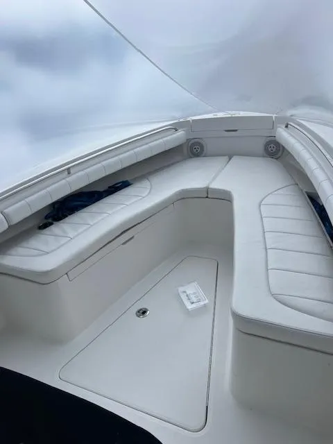 Slide: The Image of 2015 Regulator 23 Forward Seating boat with white cushioned seats and storage compartments. - 11