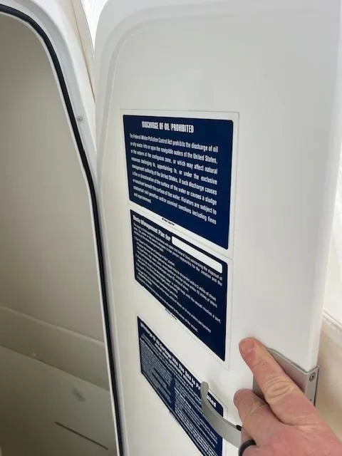 Slide: The Image of 2015 Regulator 23 Forward Seating boat door with oil discharge prohibition notice. - 18